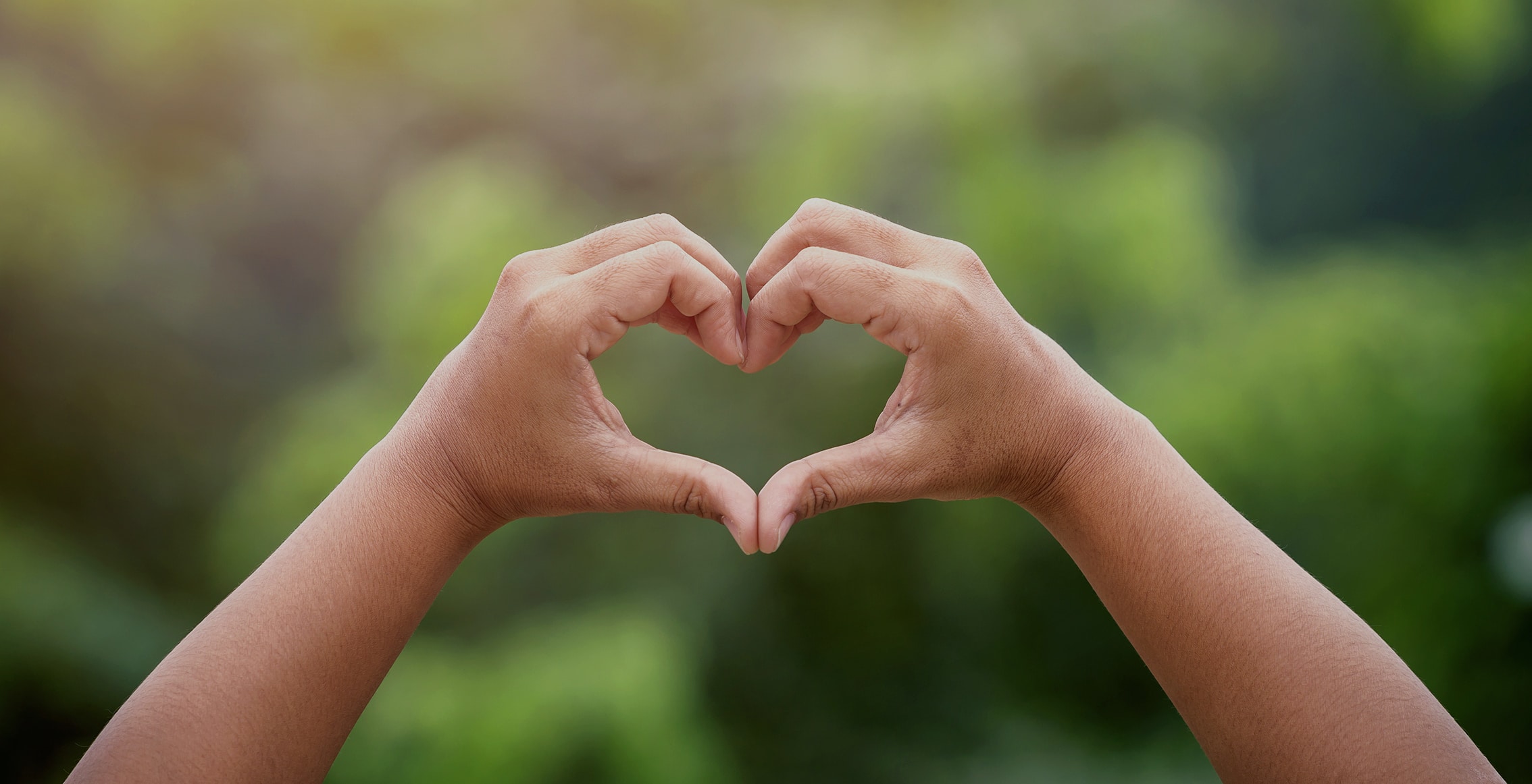 Hands forming a heart shape held up in the air