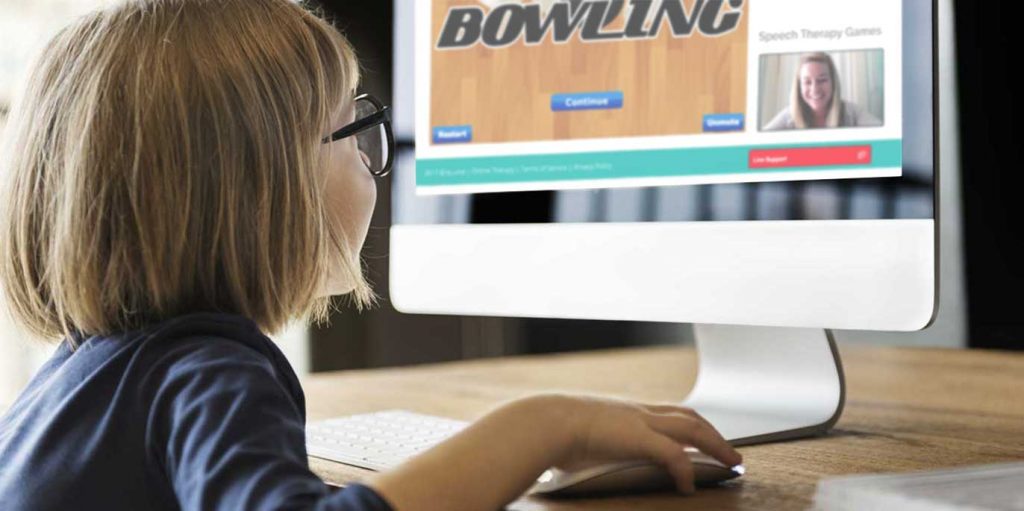 Girl working at a computer receiving online speech therapy from eLuma.