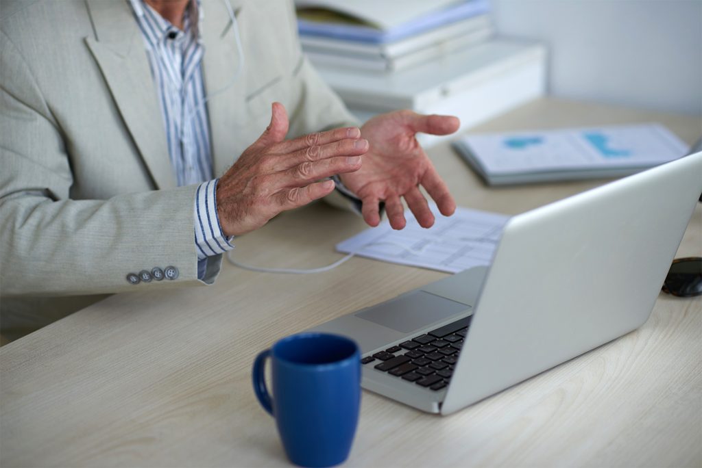 man discussing something during video interview on laptop