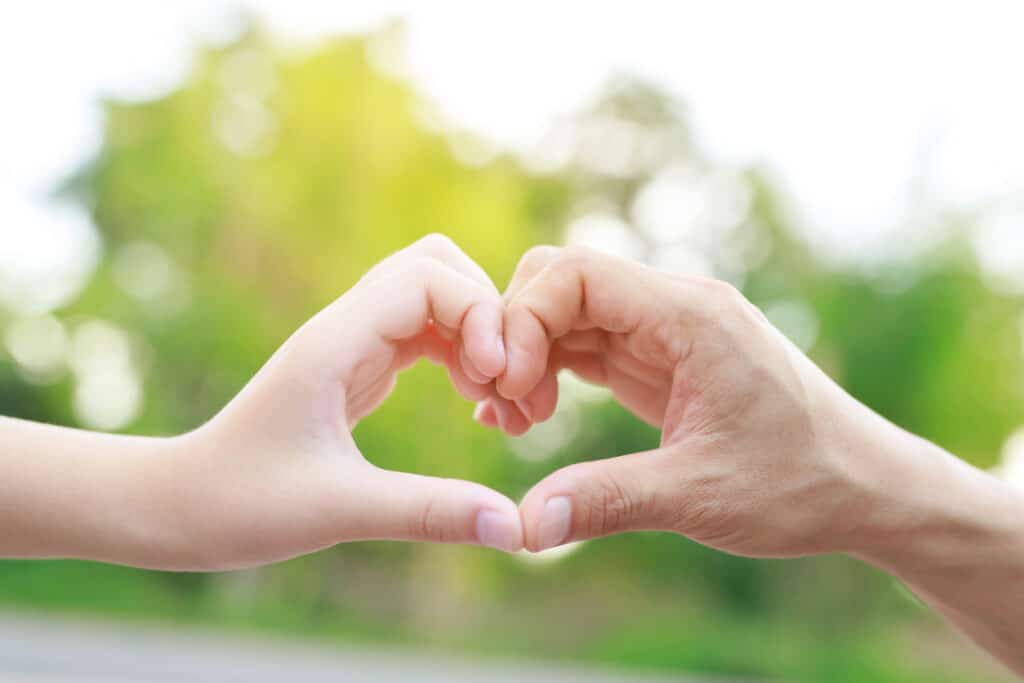 child and adult hand heart
