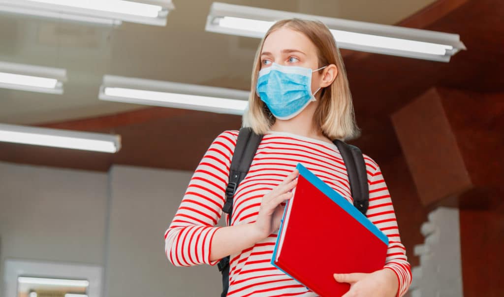 Student wearing mask heading back to school