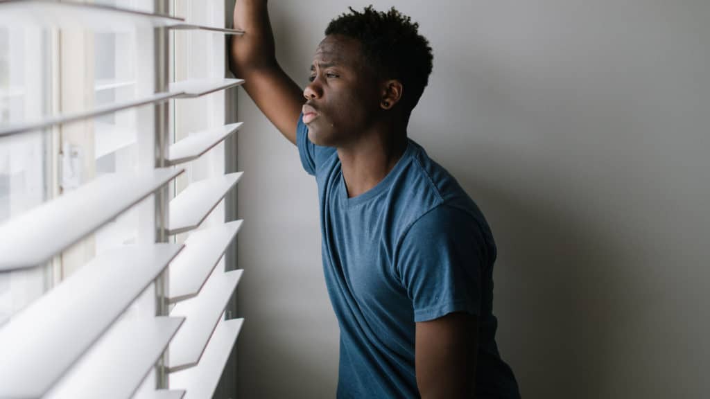 Depressed teen looking out window