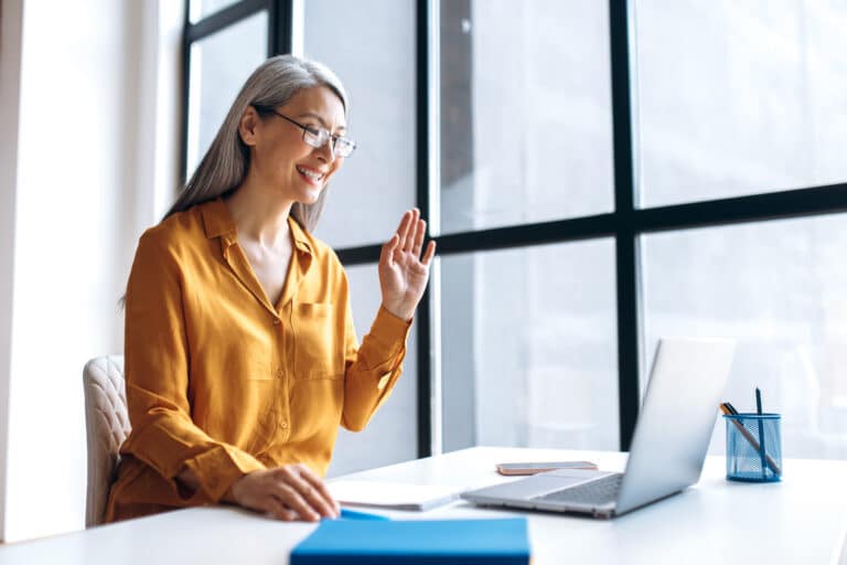 Smiling woman on video call using laptop